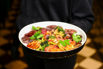 Grilled Beef Steak BBQ with roasted vegetables. Tasty meal for dinner, served by waiter in restaurant or diner.