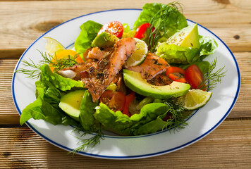 Image of delicious salad of fried trout, avocado, tomatoes and herbs