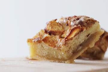 pieces of homemade apple pie with cinnamon on wooden board