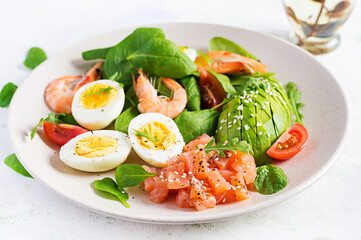 Ketogenic diet breakfast. Salt salmon salad with boiled shrimps, prawns, tomatoes, spinach, eggs and avocado. Keto, paleo lunch.
