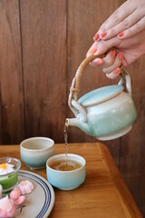 Hot tea and Thai style dessert on the wood table beside the wood wall. Cafeteria concept