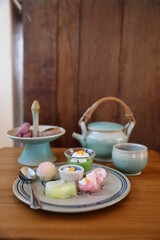 Hot tea and Thai style dessert on the wood table beside the wood wall. Cafeteria concept