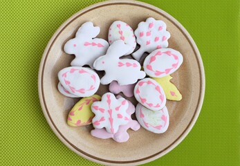 Homemade Easter gingerbreads on a plate, green background