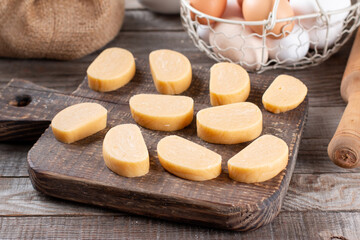 Cutting dough with a knife on the kitchen table. Concept of cooking dough, cookies, pizza,