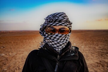 Woman in a shemagh scarf and sunglasses