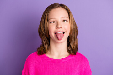Photo of funny funky young small girl make silly face stick-out tongue isolated on violet color...