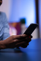 Close up of african businesswoman writing list of tasks for business project in notebook sitting at desk. Employee using modern technology network wireless doing overtime.