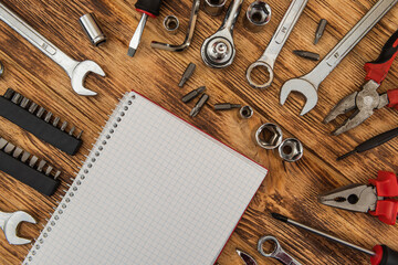 Empty notepad surrounded a set of construction tools