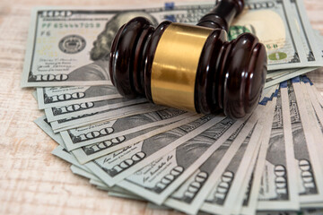 Wooden judge gavel and us money dollar bills