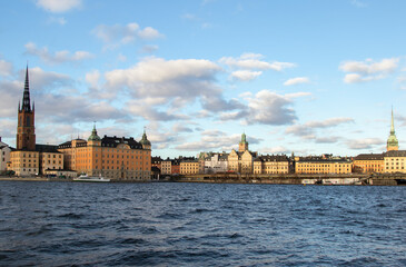 Obraz premium City view by the water under blue cloudy sky