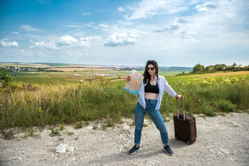 Fototapeta premium Pretty young woman stand and look at the map on the road, enjoy summer vacation