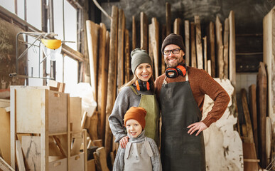 Cheerful parents with kid in craft workshop