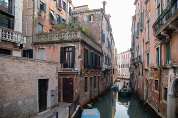 Fototapeta na wymiar Venetian canal with old building facade in a sunny day, Italy
