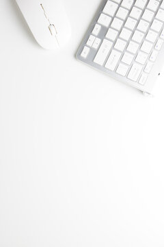 Vertical flat lay. Top view mouse and keyboard on a white office table with copy space, workspace blank. Office table concept.