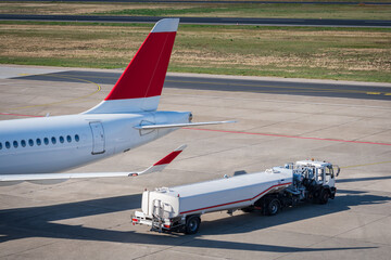 Refueling truck parked by the tail of an airplane at Tegel Airport in Berlin, Germany