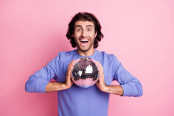 Photo of young handsome crazy excited positive good mood cheerful man hold disco ball isolated on pink color background