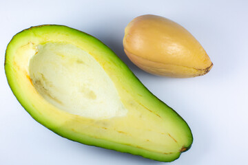 Close up photo of avocado on white background. Healthy fruit cut in half with seeds inside, macro view.