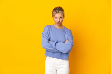 Young Russian woman isolated on yellow background feeling upset