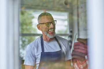 Happy middle aged caucasian man in apron smiling