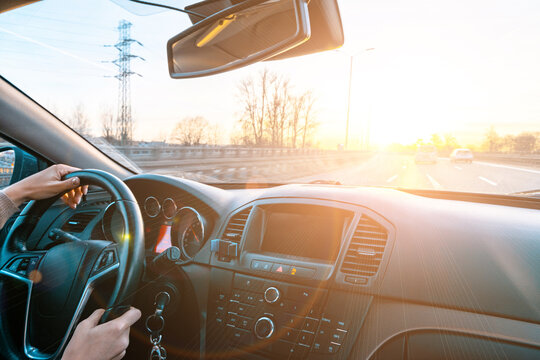 Travel trip car. Happy young woman inside vehicle driving in sunny day. Fun driver ride in winter vacation concept.