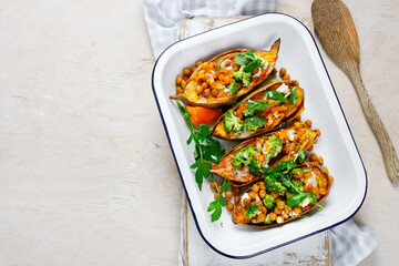 Stuffed sweet potato with spiced chickpea, dressing and herbs.