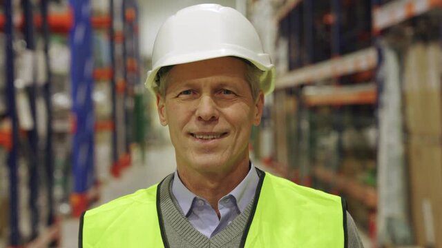 Mature male supervisor senior contractor smiling encouragingly to camera 