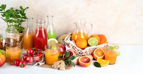 Healthy home made juices and fruits on light wooden background