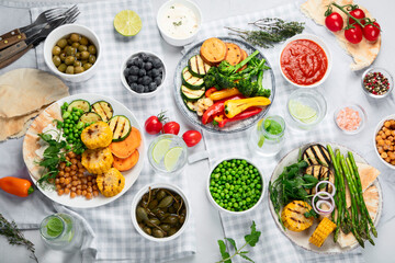 Fototapeta na wymiar Delicious grilled vegetables with sauces and snacks served on light gray background.