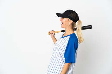 Young Russian woman playing baseball isolated on white background laughing in lateral position