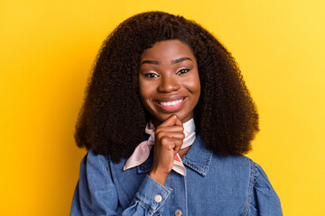 Fototapeta na wymiar Portrait of adorable friendly dark skin girl hand finger on chin toothy smile isolated on yellow color background