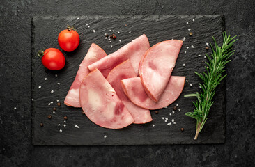 Sliced ​​ham on a stone background. Fresh prosciutto.