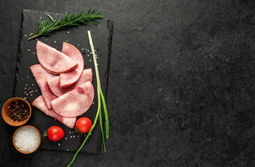 Sliced ​​ham on a stone background with copy space for your Fresh prosciutto text.