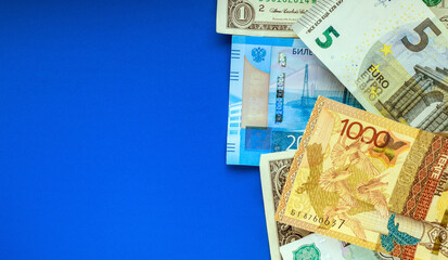 Banknotes of the USA, Europe, Russia and Kazakhstan on a blue background. Currency exchange concept. Money background. Copy space for text. Selective focus.