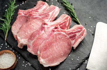 raw pork steaks on stone background