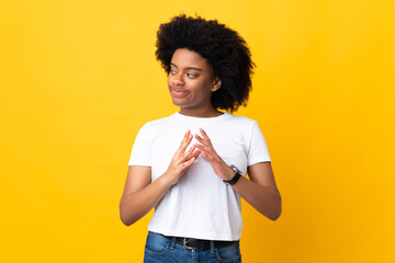 Young African American woman isolated on yellow background scheming something