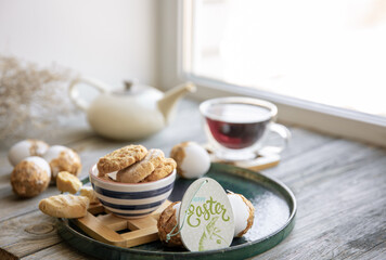 Easter composition with a cup of tea, cookies and Easter eggs close up.