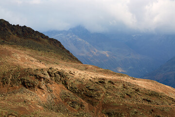 on top of a mountain with cloudy sky