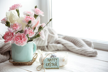 Easter composition with fresh flowers in a vase and the inscription Happy Easter on the card copy space.
