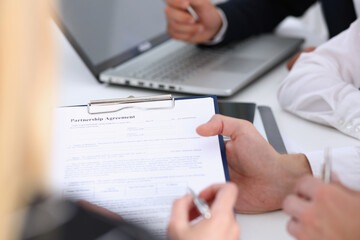 Obraz premium Male arm in suit offer contract form on clipboard pad