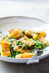 Gnocchi with peas, cheese and herbs. Italian cuisine concept.