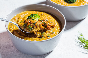 Lentil cream soup with broccoli and dill in gray bowl. Healthy vegan food concept.