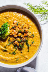 Lentil cream soup with broccoli and dill in gray bowl, top view, close up. Healthy vegan food concept.
