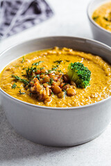 Lentil cream soup with broccoli and dill in gray bowl. Healthy vegan food concept.