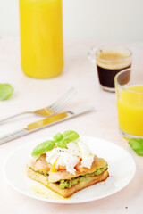 Fototapeta na wymiar Breakfast with a sandwich with poached egg and avocado