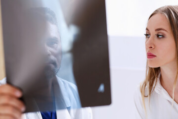 Mature male doctor hold in arm and look at xray photography