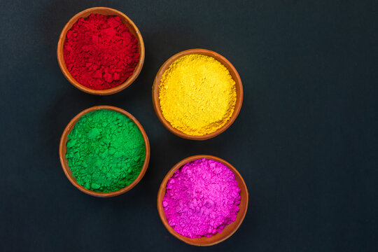 Eco-friendly Colorful Holi Powder Or Gulal In Earthen Bowl On Black Background.