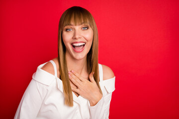 Photo of young woman happy positive smile hand touch chest humor joke laugh isolated over red color background