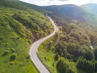 White truck or van on mountain passage road with beautiful forest