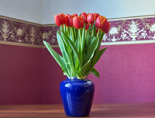 Red Tulips. Bud, petals, bouquet.Red tulips in a decorative vase stand on a table. Russia, Moscow, holiday, gift, mood, nature, flower, plant, bouquet, macro