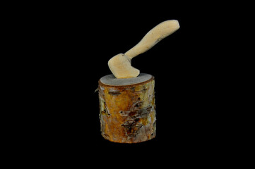 Axe in wooden log on black background close-up